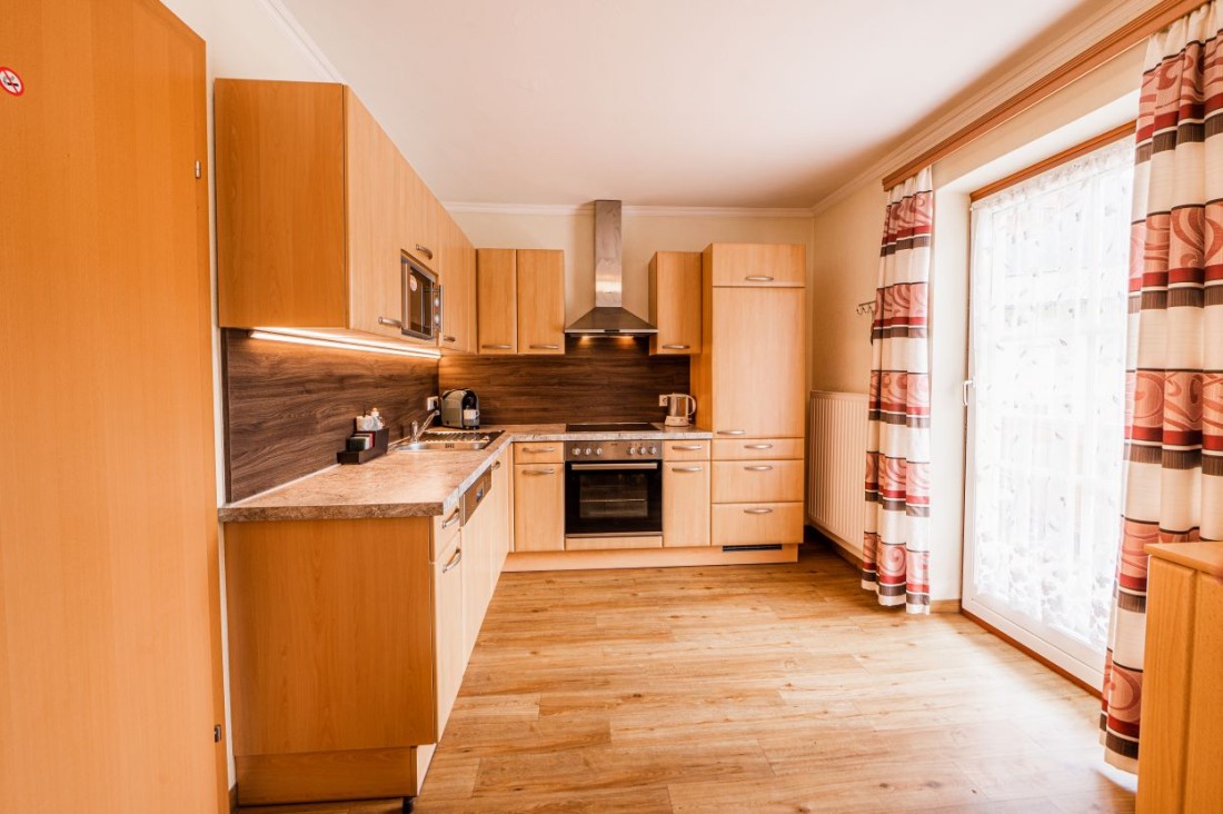 Wohnküche mit modernen Elektrogeräten und Balkon